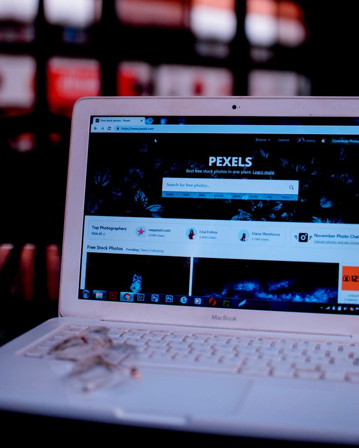 Un ordinateur portable posé sur un bureau affiche la page d’accueil de Pexels, mettant en avant son interface web.
